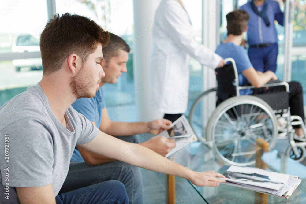 men waiting in the lobby of a hospital men waiting in the lobby of a hospital