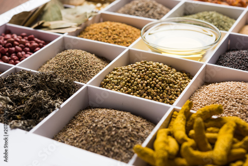 Indian Spices in white wooden box with cells, selective focus. © Arundhati