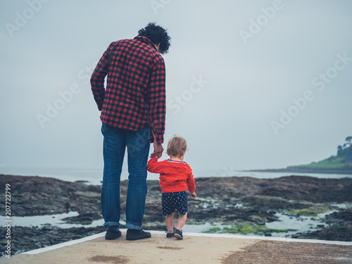 Father and small son on pier by the sea