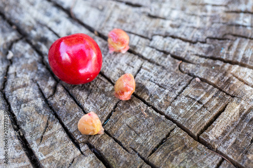 Cherries on a wooden background. The bones of the cherry. Ate cherries.