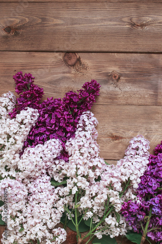 Bouquet of purple lilacs flowers on a brown wooden background