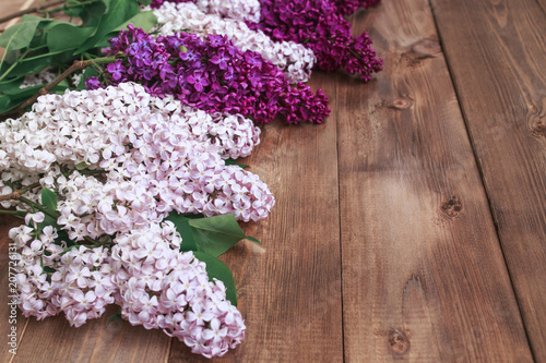 Bouquet of purple lilacs flowers on a brown wooden background