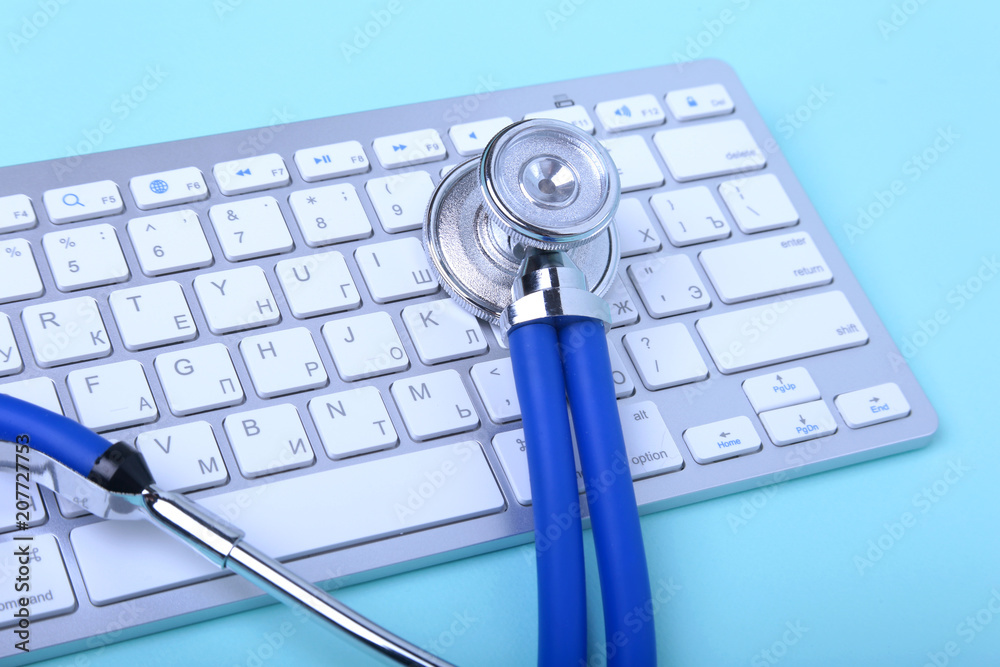 Closeup of a blue stethoscope lying on notebook keyboard and green glasses. selective focus. Closeup of a blue stethoscope lying on notebook keyboard and green glasses. selective focus.