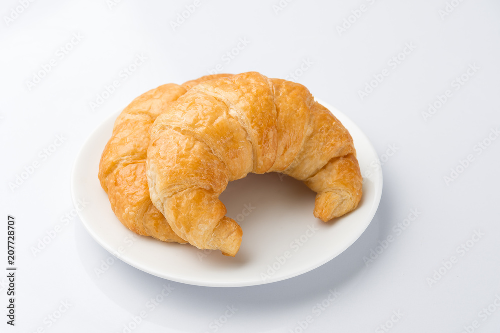 2 Delicious croissants on a white plate on a white background.