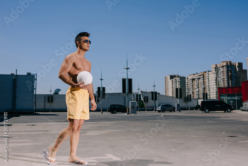shirtless man with volleyball ball on parking © LIGHTFIELD STUDIOS