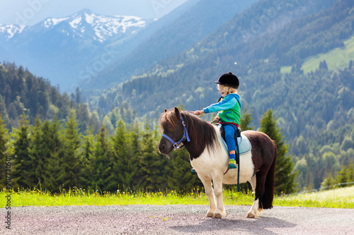 Dzieci jeżdżące na kucyku. Dziecko na koniu w Alpach góry