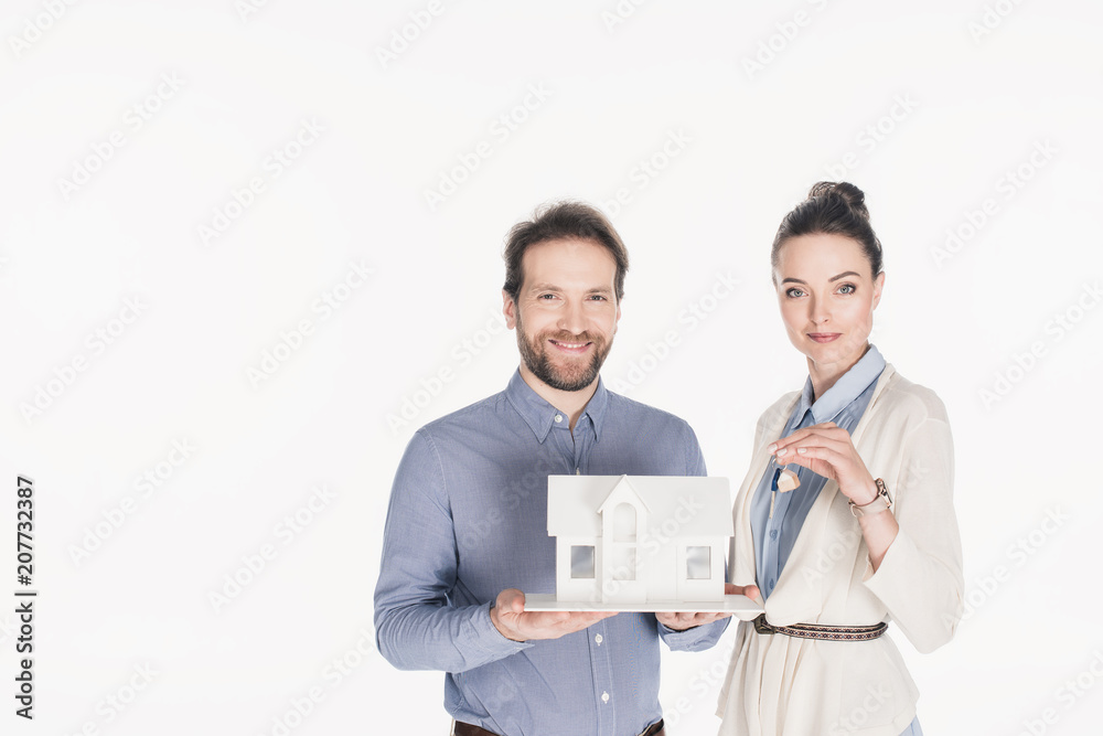 portrait of smiling married couple with house model and key isolated on white portrait of smiling married couple with house model and key isolated on white