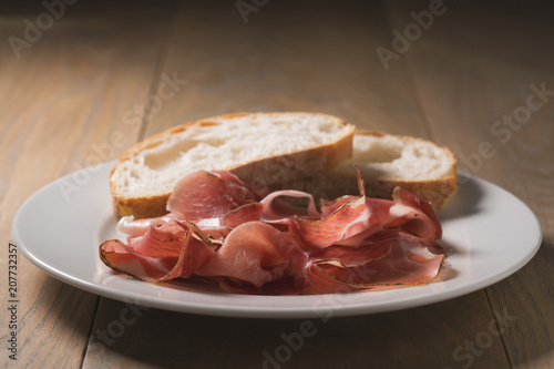 dried prosciutto ham on white plate