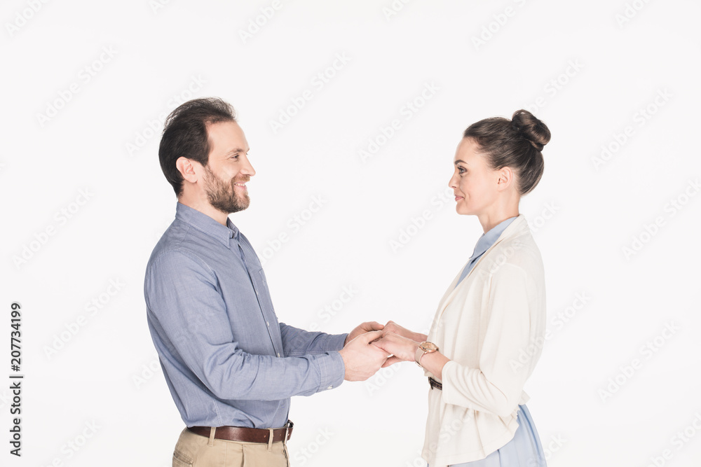 side view of smiling wife and husband holding hands together isolated on white side view of smiling wife and husband holding hands together isolated on white
