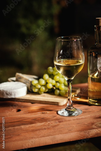 romantic dinner with a glass of wine and snacks on an old wooden table on a summer evening