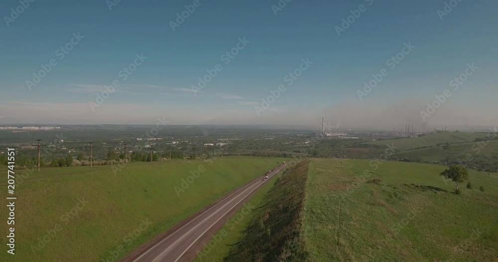 Aerial view. flies between the hills above a road to industrial enterprise. Air pollution from metallurgical plants. 4K Aerial view. flies between the hills above a road to industrial enterprise. Air pollution from metallurgical plants. 4K