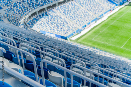 Blue seats with handrails on the tribune of the stadium.
