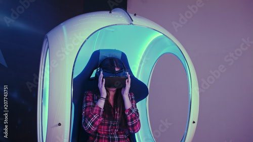 Young woman putting on virtual reality headset preparing for vr session