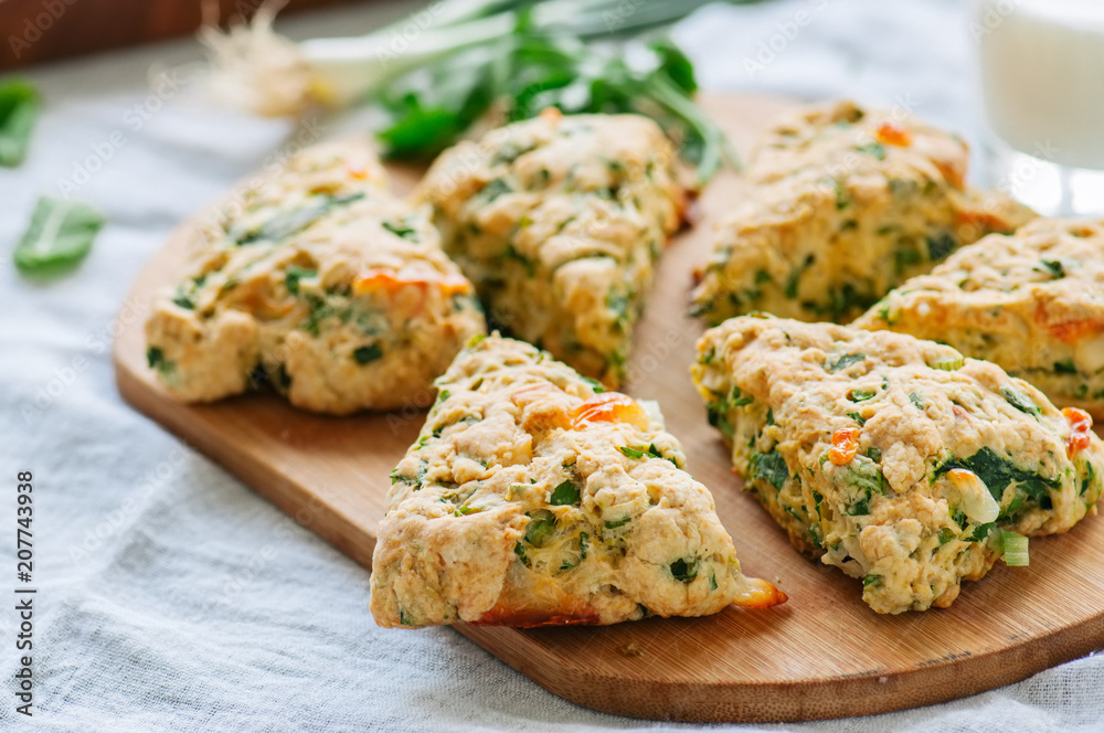 Savory scones with feta and mozarella and green herbs on a wooden board. Savory scones with feta and mozarella and green herbs on a wooden board.