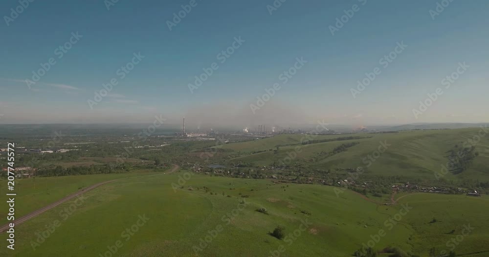 Aerial view. flies between the hills above a road to industrial enterprise. Air pollution from metallurgical plants. 4K Aerial view. flies between the hills above a road to industrial enterprise. Air pollution from metallurgical plants. 4K