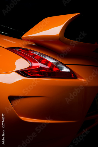 Car detailing series: Clean of rear orange sports car in the dark