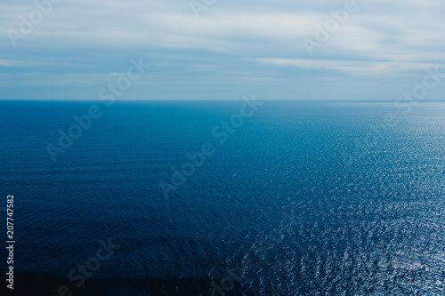 Calm blue sea without waves seen from a cliff with room for text