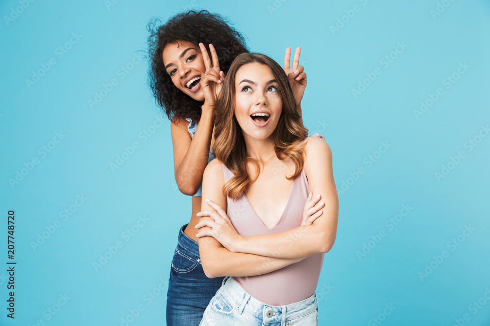Fototapeta premium Two cheerful young girls dressed in summer clothes