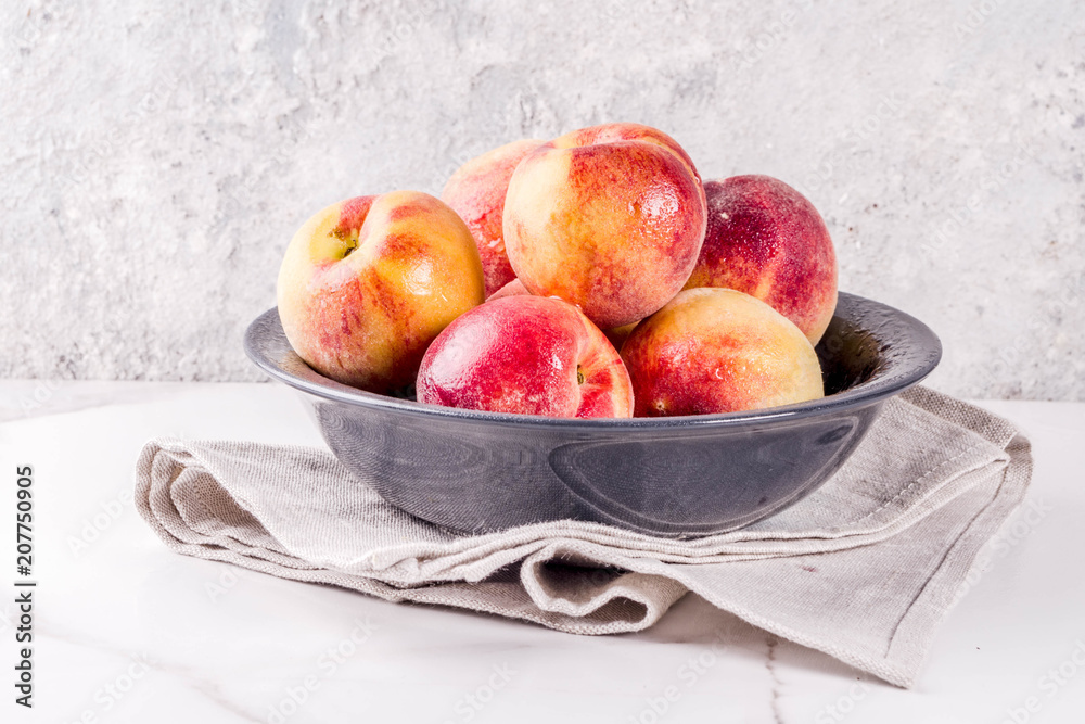 Raw fresh peaches in bowl on grey concrete background copy space Raw fresh peaches in bowl on grey concrete background copy space