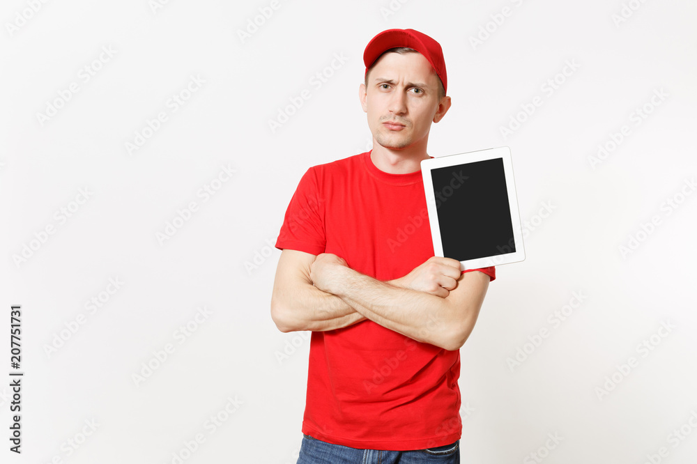 Delivery man in red uniform isolated on white background. Male in cap, t-shirt, jeans working as courier or dealer, holding tablet pc computer with blank empty screen. Copy space for advertisement.
