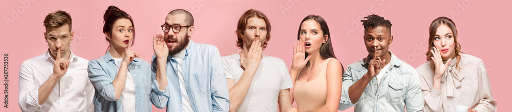 The young men and women whispering a secret behind hands over pink background The young men and women whispering a secret behind hands over pink background