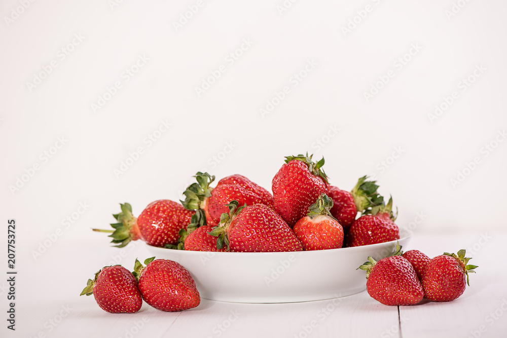 red ripe strawberries on white background in a bowl red ripe strawberries on white background in a bowl