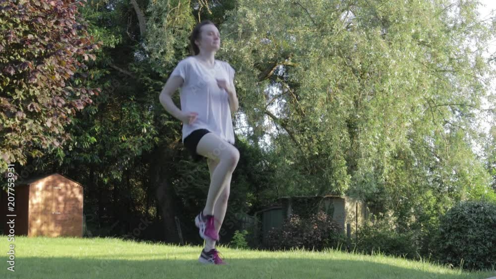 Young woman doing jump exercises on the grass Young woman doing jump exercises on the grass