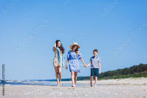 Mother and her two children walking on the beach