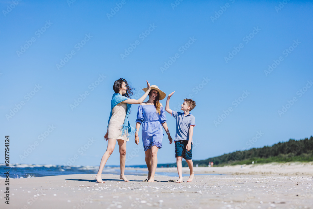 Mother with children walking by the sea