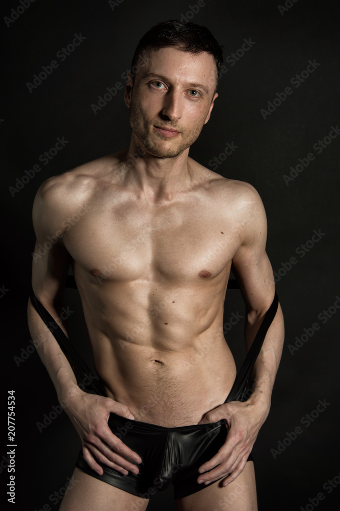 Sexy man without a shirt. Black background.