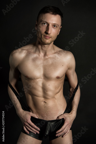 Sexy man without a shirt. Black background.