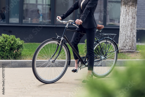 Fototapeta Naklejka Na Ścianę i Meble -  cropped shot of businesswoman in suit with retro bicycle on street