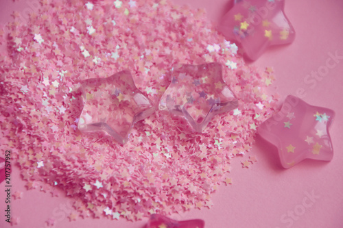 Pink stars lying in glitters. Abstract background