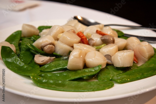 Stir-fried scallops with snow pea and mushroom, a popular dish in a chinese restaurant