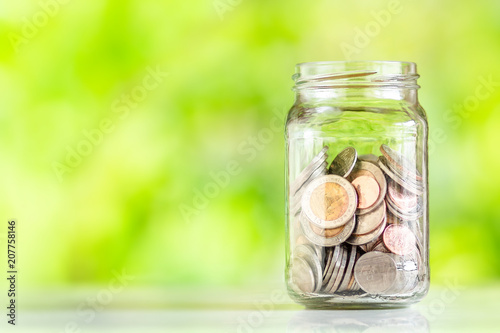 Save money interest Plant Growing In Savings Coins money in the glass saving money with hand putting coins Green Natural background