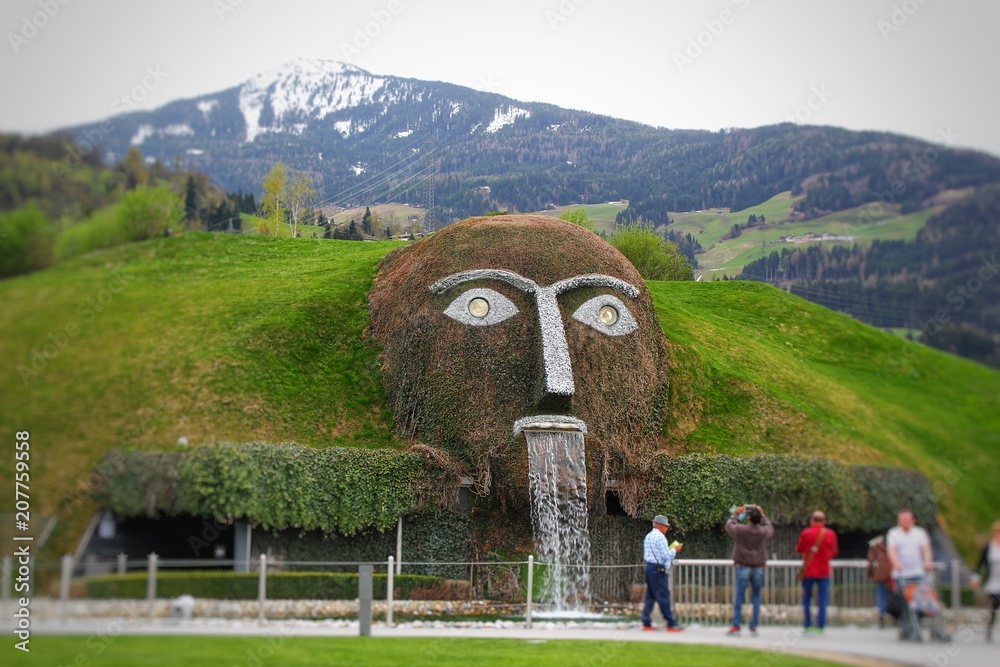Monster giant head fountain spitting water into a pond at swarovski  Kristallwelten in Wattens, Austria with cloudy skies and snowy Alps in  background Stock Photo | Adobe Stock
