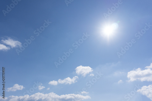 Deep blue sky with clouds and sunlight rays .