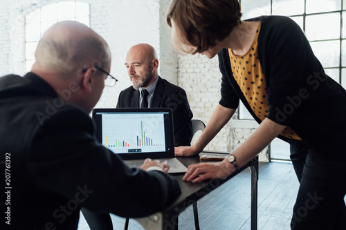 Colleagues looking at graphical data on laptop