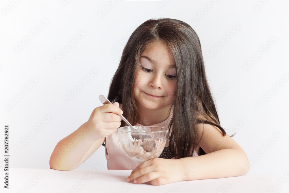 Happy child girl eating ice cream in white and chocolate bowl on white background. Enjoying delicious. Happy child girl eating ice cream in white and chocolate bowl on white background. Enjoying delicious.