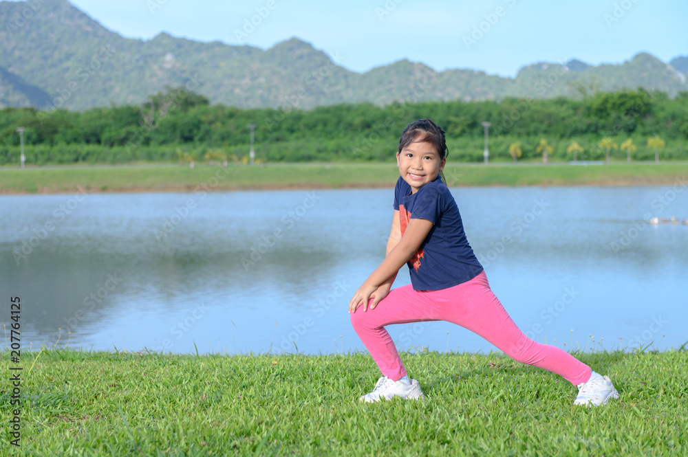 Obraz premium cute girl exercise on green grass