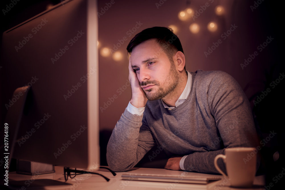 Man working on computer late at night Man working on computer late at night