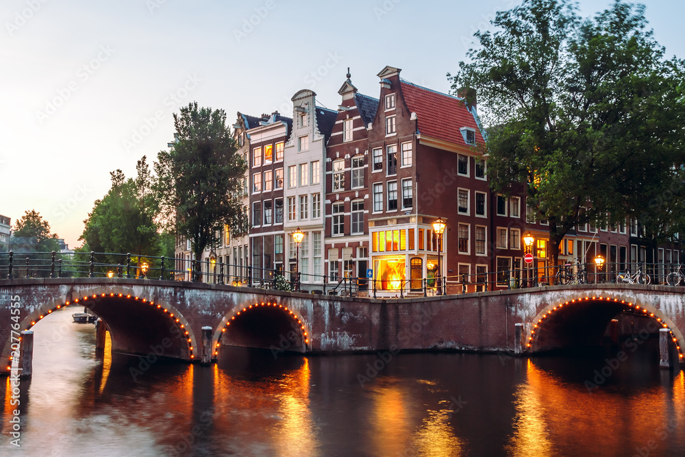 Naklejka premium Evening building on the streets and amsterdam channels with illumination