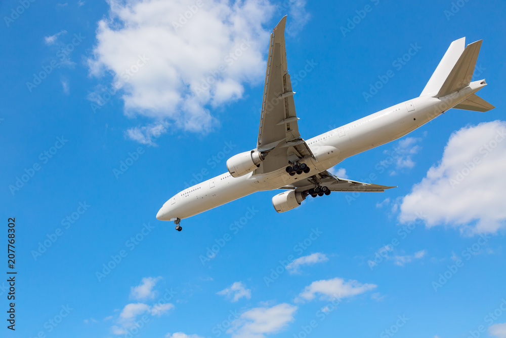 Commercial airliner flying near clouds and landing with blue sky. Travel or business trip concept image. Commercial airliner flying near clouds and landing with blue sky. Travel or business trip concept image.