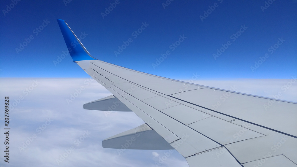 Fototapeta premium Widok szarego skrzydła samolotu przez okno samolotu