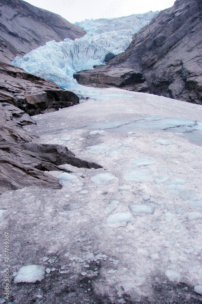 Panorama of a melting glacier between the high cliffs of the Norwegian fjords. Panorama of a melting glacier between the high cliffs of the Norwegian fjords.