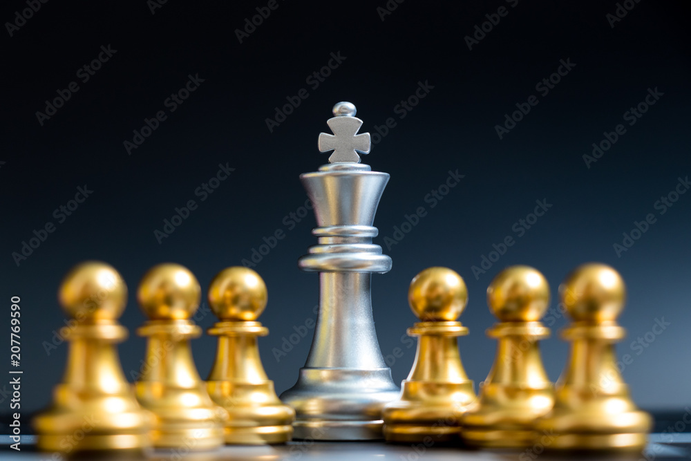 Silver king chess piece stand with pawn on black background Silver king chess piece stand with pawn on black background