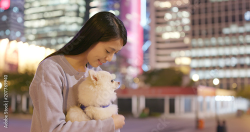 Photography Woman hugging with her pomeranian dog in city at night