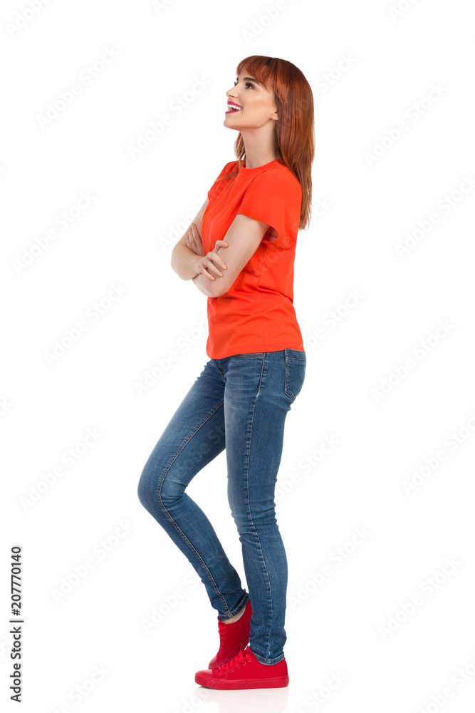 Young Woman Is Standing With Arms Crossed, Looking Away And Talking