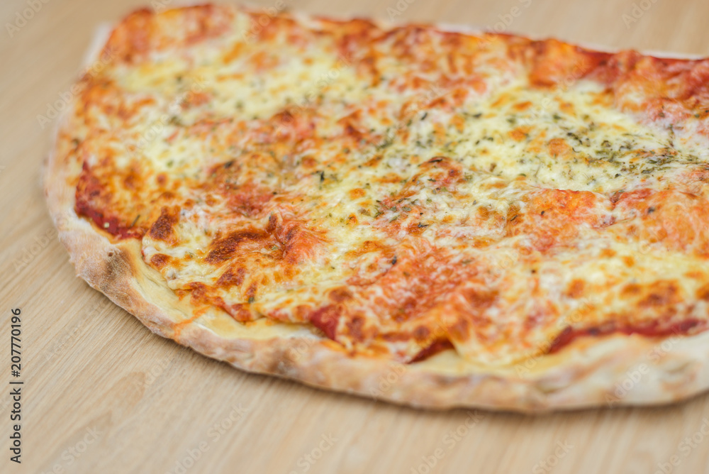 Closeup on traditional fresh pizza, top side view wooden background