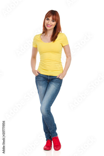 Smiling Casual Young Woman Is Standing With Hands In Pockets